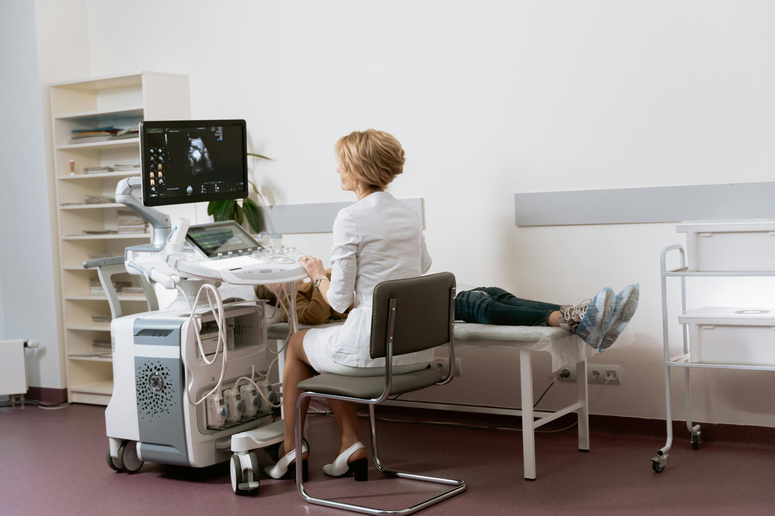 Doctor performing ultrasound scan on patient in modern clinic.